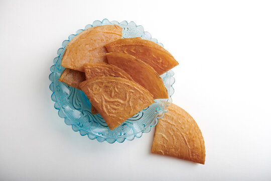 Stacked Kuih Kapit on Vintage Blue Glass Plate, Top View and isolated on white background