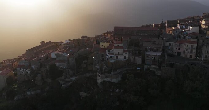 Aerial view of Pollina village on a hill, bathed in the warm glow of the sun, showcasing the rustic charm and architectural beauty of the old town, Pollina, Sicilia, Italy.