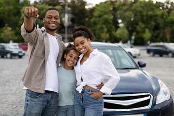 New Car. Happy Black Family Showing Own Automobile Key To Camera Standing Near Auto Posing Outdoor....