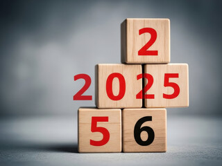 Wooden blocks stacked together showing red and black numbers forming various years including twenty twenty six against blurred indoor room background
