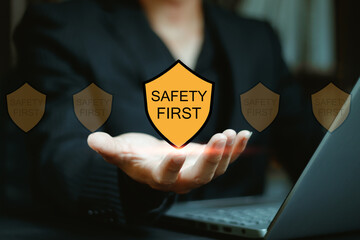 Businessman holding glowing safety first shield icon representing workplace protection risk management corporate responsibility employee care compliance culture and modern security awareness concept.