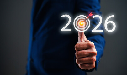 A business professional signals success and goal achievement for 2026 with a thumbs-up gesture, highlighting ambition and future planning.