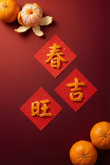 Lunar New Year Chinese Characters Chun Ji Wang Made of Mandarin Orange Peel on Red Paper Flat Lay