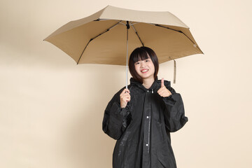 20s Asian woman wearing raincoat
