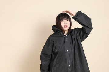 20s Asian woman wearing raincoat