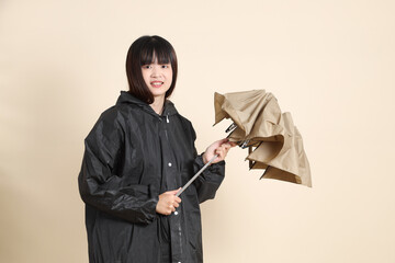 20s Asian woman wearing raincoat