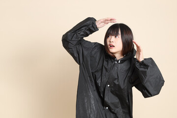 20s Asian woman wearing raincoat