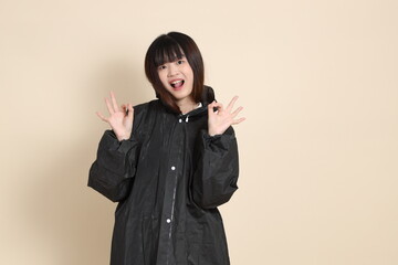 20s Asian woman wearing raincoat
