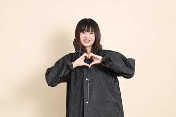 20s Asian woman wearing raincoat