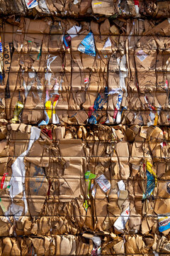 Compacted compressed cardboard for recycling, a central collection point for processing and reuse of materials.