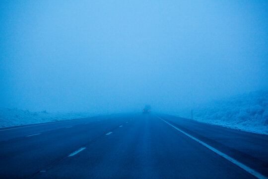 Foggy winter highway, the Interstate 90 at dusk, driving in poor visibility.
