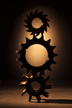 Wheels as gears, a balanced stack of three different metal cog wheels with different shaped exterior shapes.