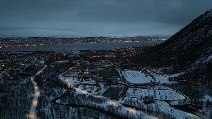 Drone photography of the city of Tromsdalen, in the foreground, and the island of Tromsø in the background, during a lovely spring evening in the arctic circle, Norway. © Threed4wg