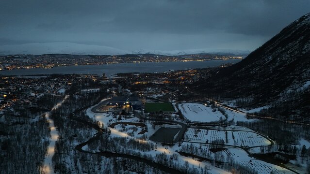 Drone photography of the city of Tromsdalen, in the foreground, and the island of Troms&oslash; in the background, during a lovely spring evening in the arctic circle, Norway.