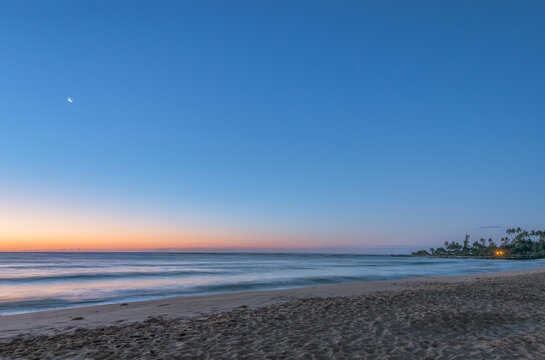Hawaii, Kauai, Wailua Beach at dawn, the sun on the horizon, view out to sea.