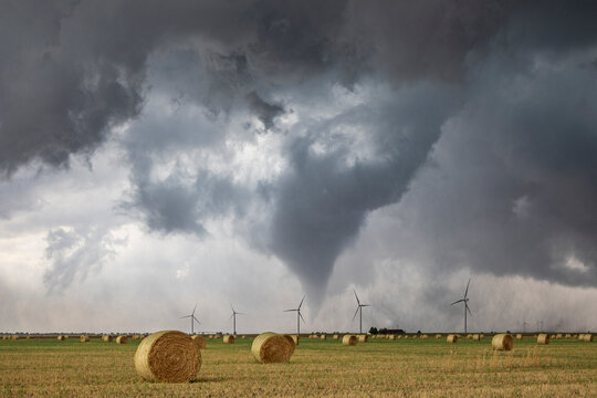 Tornado Touchdown, a Tornado-Producing Supercell, tornados reaching down to the ground n the horizon.