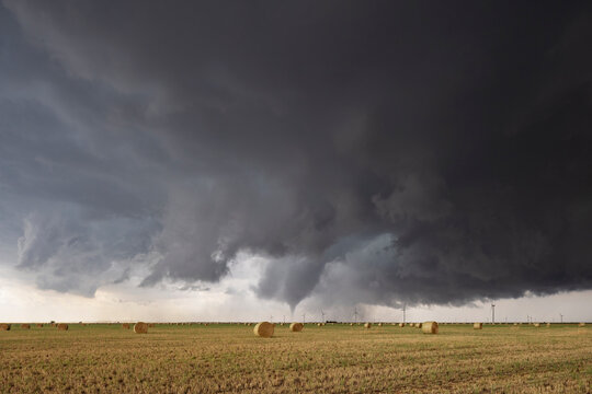 Tornado Touchdown, a Tornado-Producing Supercell, tornados reaching down to the ground n the horizon.