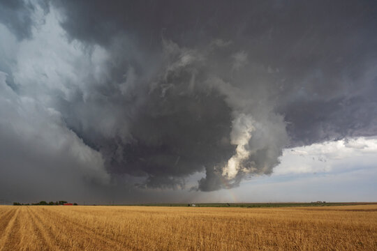 The back side of a Tornado-Warned Supercell, clouds on the horizon over farmland.