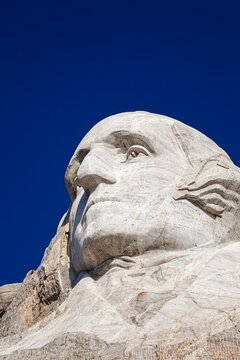 Close view of George Washington carved in granite at Mount Rushmore National Memorial under a clear blue sky in the Black Hills of South Dakota.