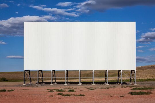 A large white drive-in movie screen stands on the prairie in rural South Dakota, offering ample copy space and a clean, minimal scene.