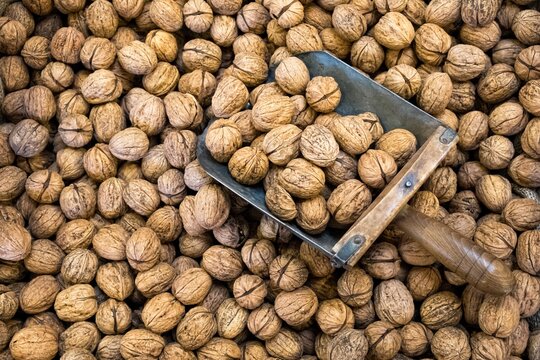 Close-up of walnuts with a metal scoop at a market 