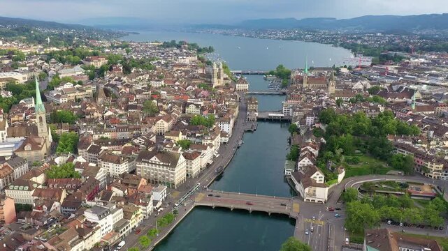Zurich, Switzerland: Aerial drone footage of Zurich old town with the Limmat river the Grossmunster cathedral and the lake in the back in Switzerland largest city. 