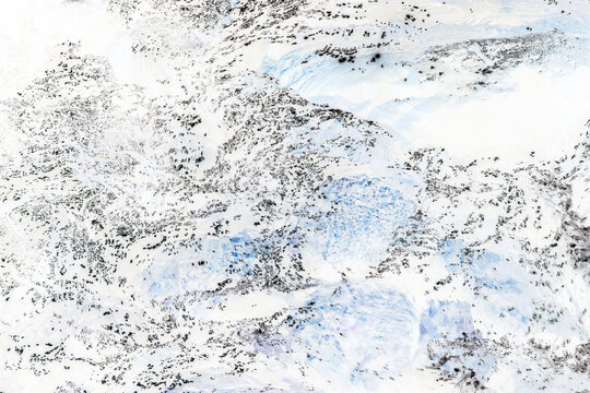 River water abstract, long exposure of river water flowing over boulders and rocks, blue, white and grey colours.