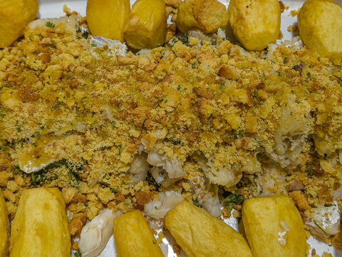 Traditional portuguese codfish tray with grelos, baked potatoes and crunchy toasted corn bread crumbs on top, homemade christmas season meal served in metal roasting pan