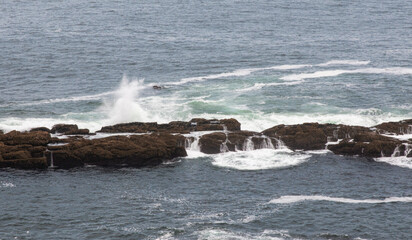 Waves crash on rocks near the Tower of Hercules in La Coruna Spain