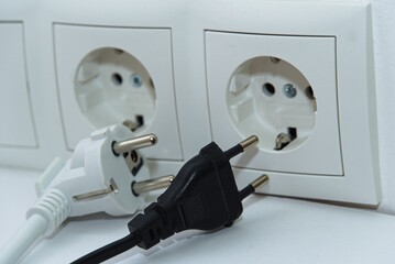 Hybridstecker und Eurostecker vor Steckdosen