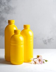 Three Yellow Bottles with Flowers on White Surface.