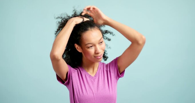 Beautiful smiling woman tying her curly hair in a bun