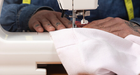 Person sewing white fabric with a machine