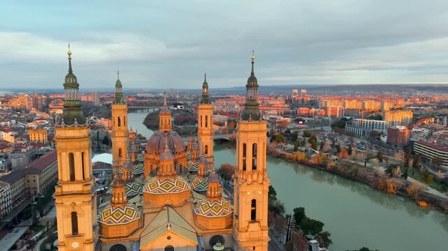 Aerial View Capturing Sunset Glow Illuminating Cathedral Domes And Tranquil River Reflections. Zaragoza. Spain 