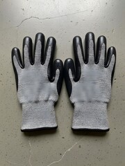 Protective gloves laid out on a cracked concrete surface for safety purposes