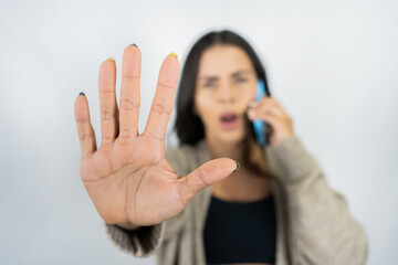 Woman making stop gesture expressing boundaries during phone call