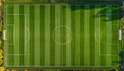 Top-down aerial view of a professional green soccer field with white markings and alternating mowed stripes