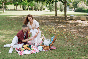Young family enjoying a happy picnic in park