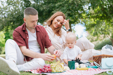 Happy family enjoying summer picnic together in park
