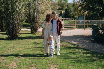 Young family showing affection outdoors in park