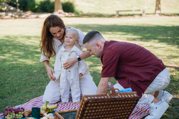 Happy family enjoying picnic in green park