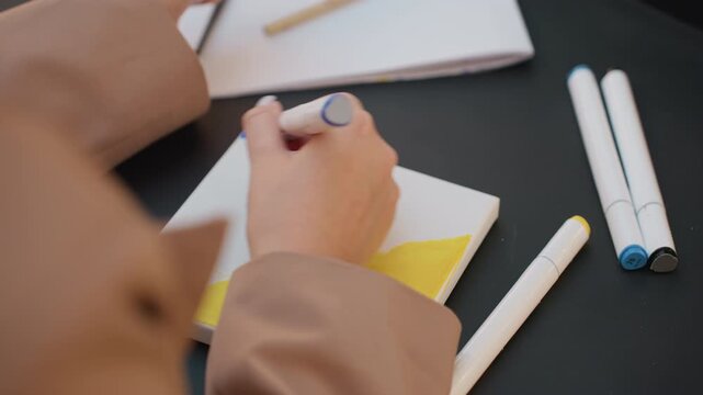 creative process starts on canvas, initial artistic marks are laid down during peaceful studio session, focused hands compose preliminary lines on tiny canvas as inspiration sparks