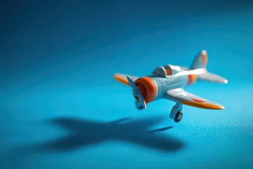 Small plastic aircraft toy captured in motion with a blue seamless backdrop