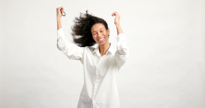 Beautiful smiling woman letting her curly hair down