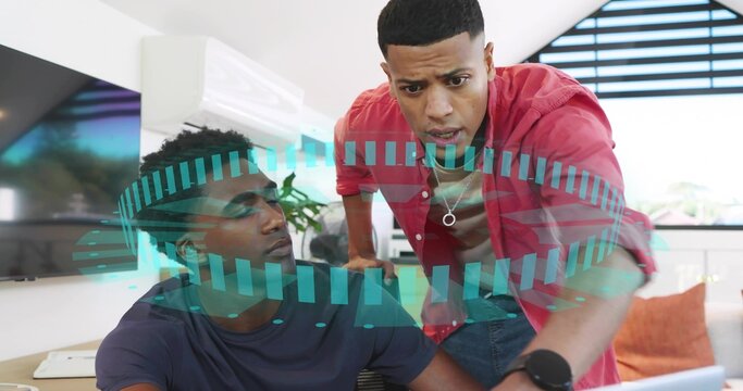 Leaning red-shirt man guiding navy T-shirt man at home office with laptop AR overlay - Powered by Adobe