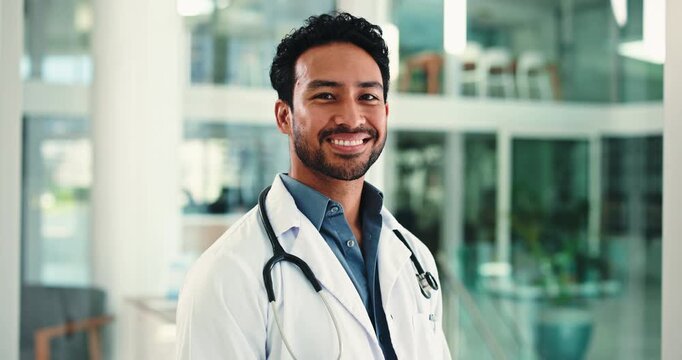 Face, doctor and man with smile, hospital and confident with healthcare career, medicine or wellness. Clinic, medical professional and person with pride for health service, happy or positive attitude