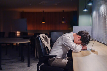 夜遅くまで仕事をしてオフィスで寝落ちをしてしまう男性