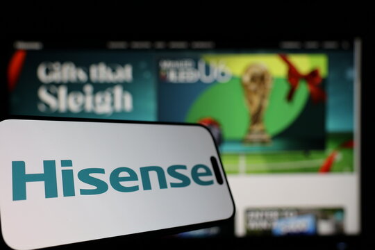 Kiel, Germany - 01-12-2026: Smartphone displaying Hisense logo in front of the company website on a monitor