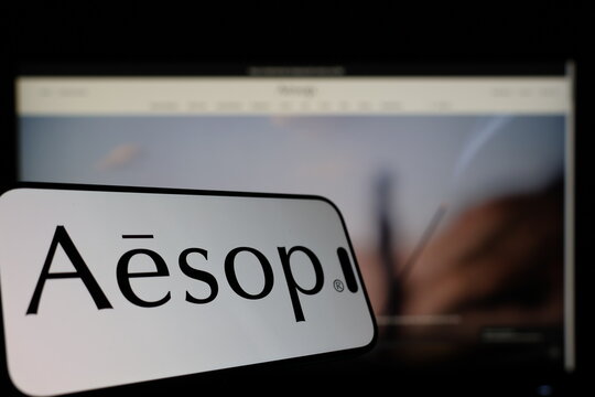 Kiel, Germany - 01-12-2026: Smartphone displaying Aesop logo in front of the company website on a monitor