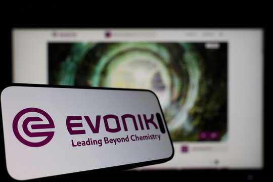 Kiel, Germany - 01-12-2026: Smartphone displaying Evonik logo in front of the company website on a monitor